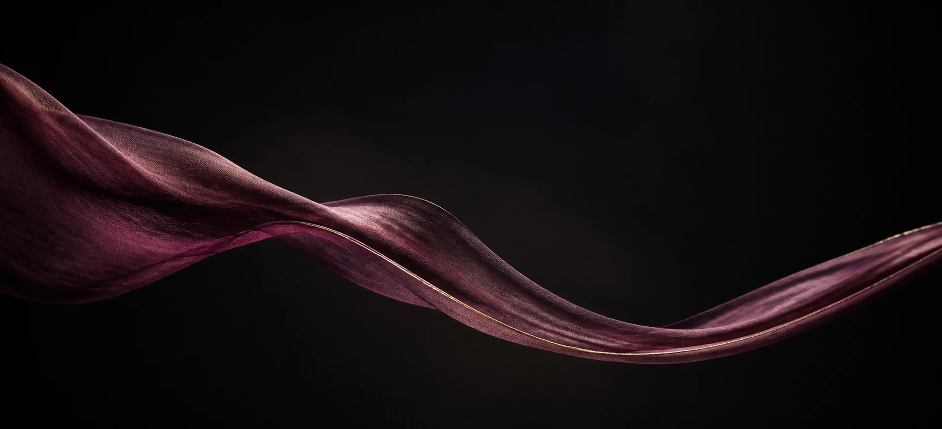 A translucent plum fabric moving slowly through a dark space